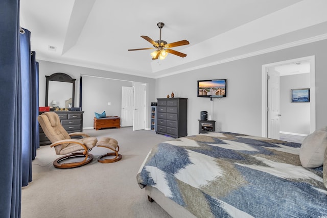 bedroom featuring a tray ceiling, carpet floors, ceiling fan, and baseboards