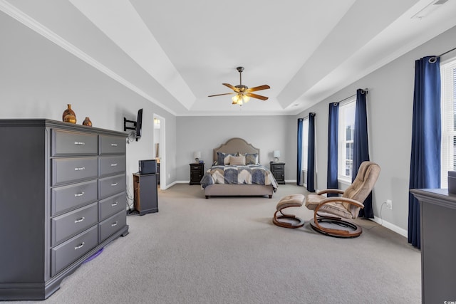 bedroom featuring a raised ceiling, baseboards, light carpet, a ceiling fan, and crown molding