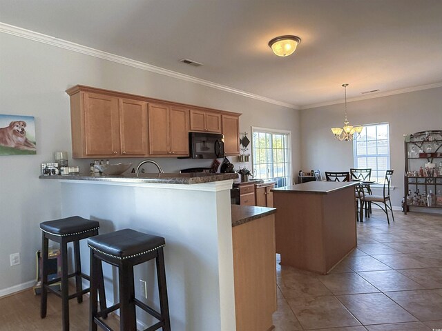 kitchen with a kitchen island, black appliances, kitchen peninsula, sink, and ornamental molding