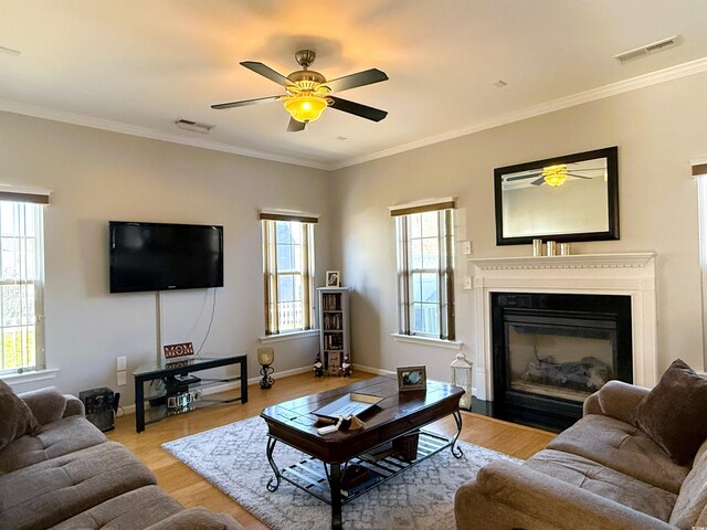 living room with light wood-type flooring, an inviting chandelier, and ornamental molding