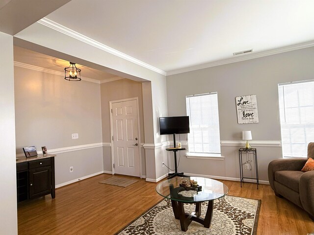 dining space featuring ornamental molding, light hardwood / wood-style flooring, and a notable chandelier