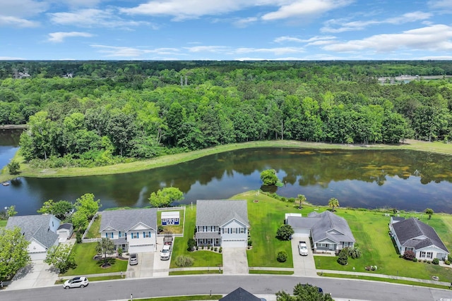 aerial perspective of suburban area featuring a forest and a large body of water