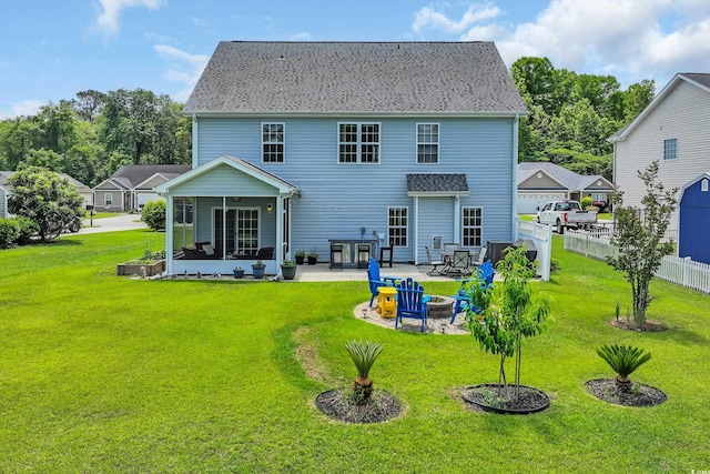rear view of property with a sunroom, a patio area, and an outdoor fire pit
