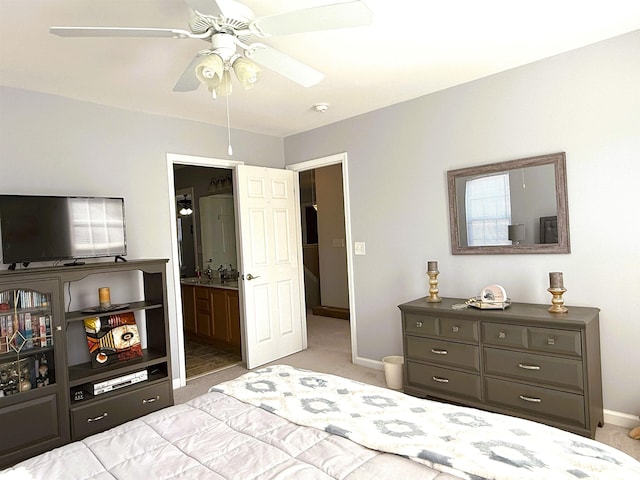 carpeted bedroom with ensuite bathroom, a ceiling fan, and baseboards