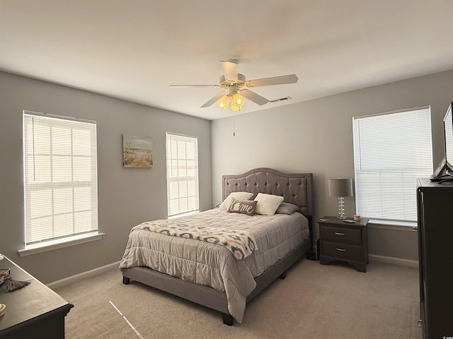 bedroom featuring visible vents, baseboards, ceiling fan, and light colored carpet