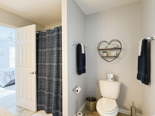 ensuite bathroom with ensuite bathroom, toilet, a ceiling fan, baseboards, and a shower with curtain