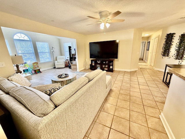 tiled living room featuring ceiling fan and a textured ceiling