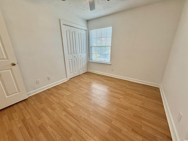 4273 Santolina Way Unit E, Murrells Inlet, SC 29576 - unfurnished bedroom with a textured ceiling, light wood-style flooring, baseboards, a closet, and ceiling fan
