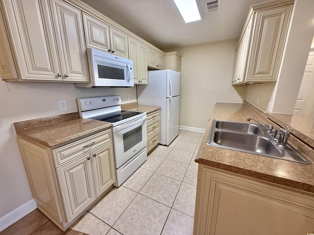 4273 Santolina Way Unit E, Murrells Inlet, SC 29576 - kitchen with white appliances, a sink, light tile patterned floors, baseboards, and cream cabinets
