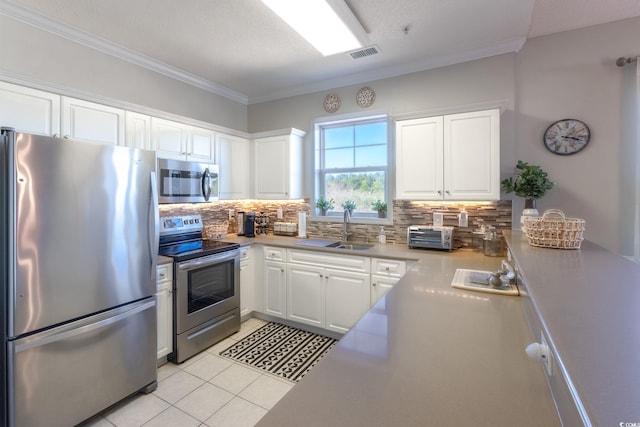 kitchen featuring visible vents, backsplash, appliances with stainless steel finishes, and white cabinetry