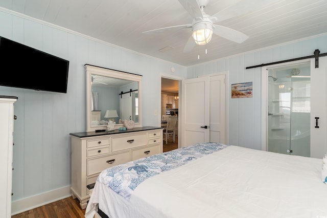 bedroom featuring ceiling fan, a barn door, dark wood-type flooring, and crown molding