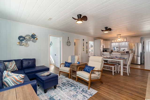 living room featuring wood-type flooring, wood ceiling, and ceiling fan with notable chandelier