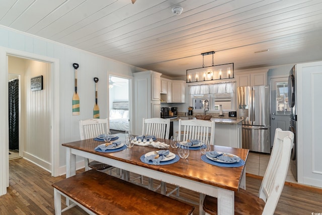 dining space with a chandelier, light hardwood / wood-style flooring, ornamental molding, and wood ceiling