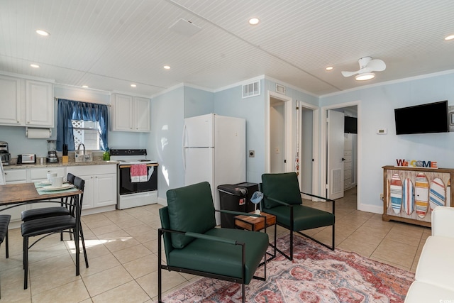 kitchen featuring light tile patterned floors, ceiling fan, white appliances, crown molding, and white cabinets