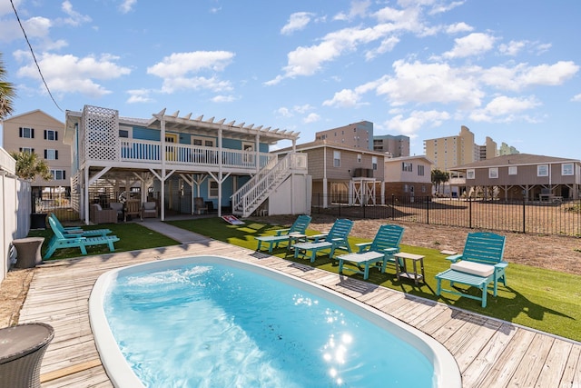 view of swimming pool featuring a lawn, a pergola, and a deck