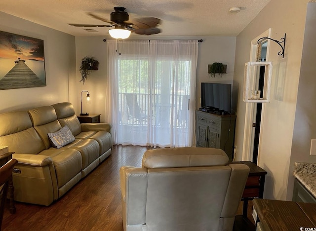 living room with ceiling fan, dark hardwood / wood-style flooring, and a textured ceiling