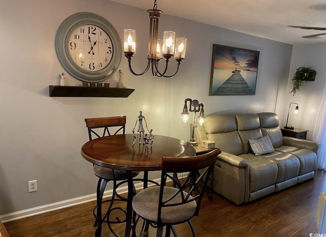 dining area with dark wood-type flooring and a chandelier