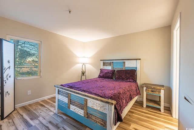 bedroom with baseboards and light wood finished floors