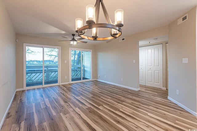 empty room with light wood-style floors, visible vents, and baseboards