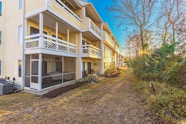 view of home's exterior with cooling unit and a sunroom