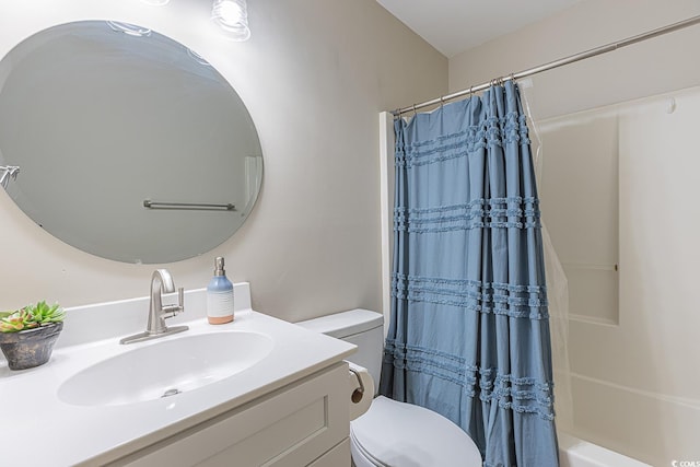 bathroom with shower / tub combo with curtain, vanity, and toilet