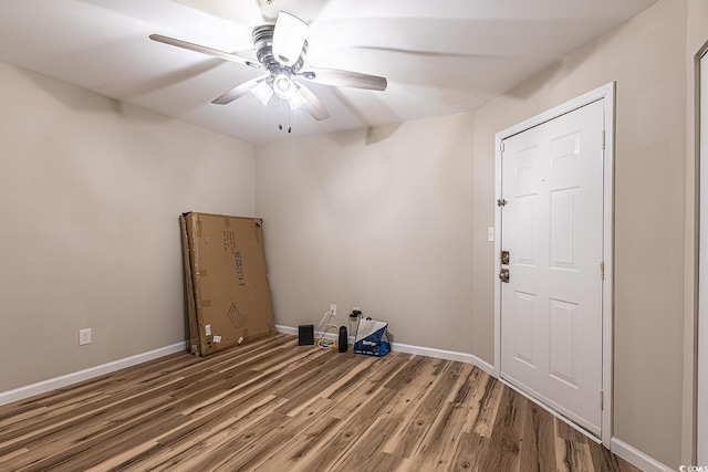 laundry room with a ceiling fan, wood finished floors, and baseboards