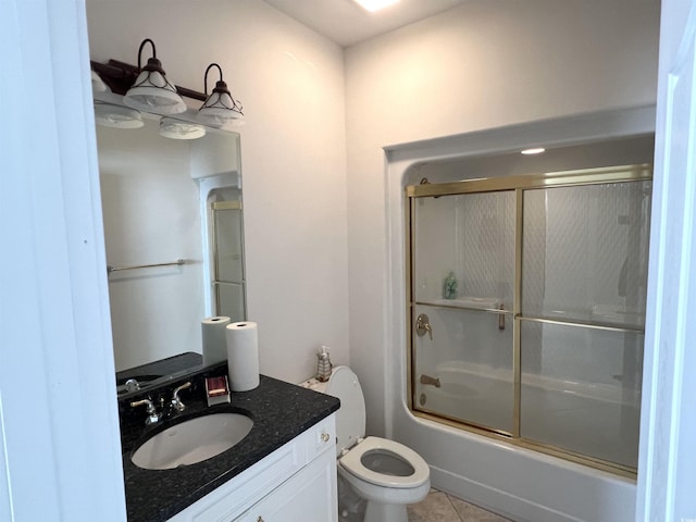 full bathroom featuring vanity, toilet, combined bath / shower with glass door, and tile patterned flooring