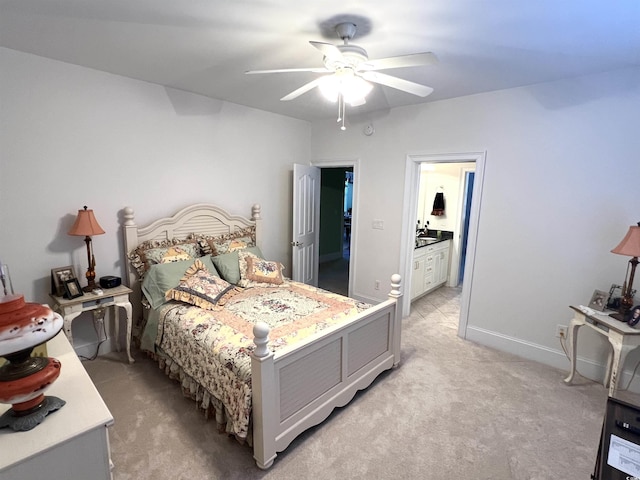 bedroom with sink, ceiling fan, ensuite bathroom, and light carpet