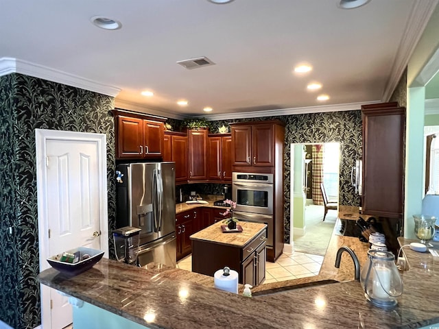 kitchen featuring crown molding, sink, dark stone counters, a kitchen island, and stainless steel appliances