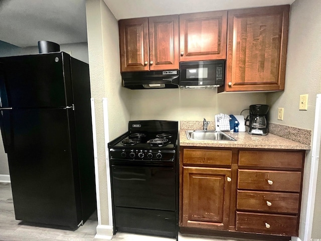 kitchen featuring light wood-type flooring, sink, and black appliances