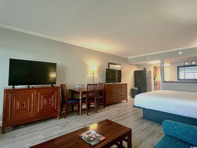 bedroom with ensuite bathroom, stainless steel refrigerator, crown molding, and light hardwood / wood-style floors