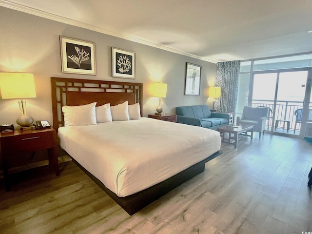 bedroom featuring a wall of windows, wood-type flooring, access to exterior, and crown molding