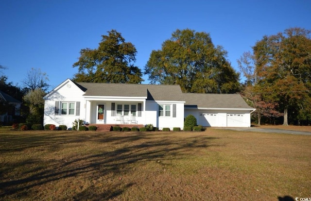 ranch-style home featuring a garage, covered porch, and a front yard