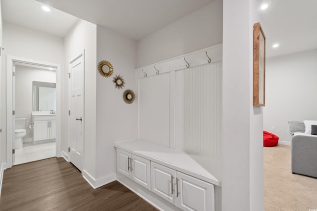 mudroom with dark wood-style floors, recessed lighting, and baseboards