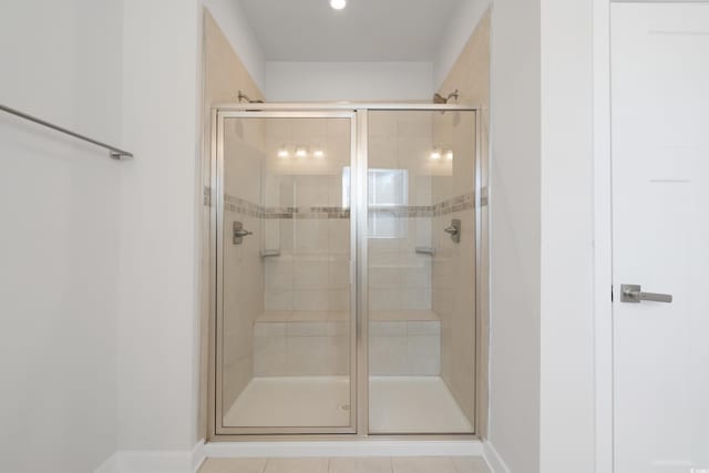 bathroom with baseboards, a stall shower, and tile patterned floors