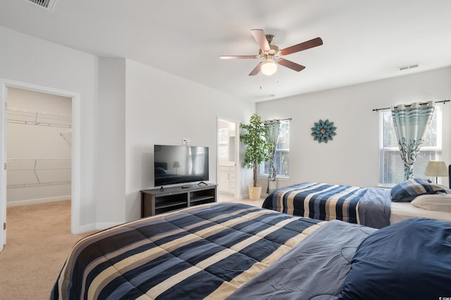 bedroom with ensuite bathroom, a ceiling fan, visible vents, baseboards, and carpet