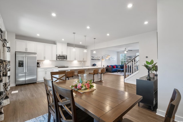 dining room with dark wood-style flooring, recessed lighting, stairway, a ceiling fan, and baseboards