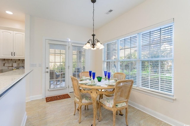 dining room featuring light tile patterned flooring and an inviting chandelier