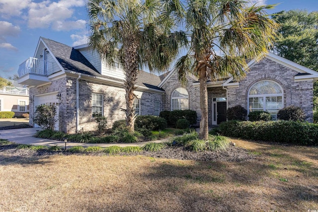 view of front of property with a balcony, a front yard, and a garage