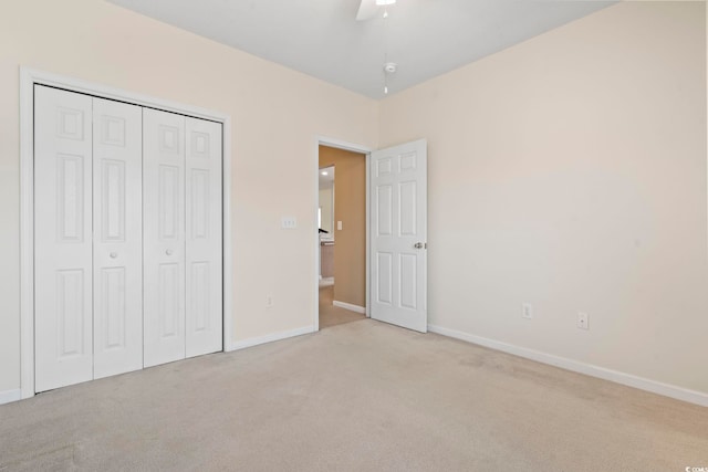 unfurnished bedroom with a closet, carpet, and baseboards