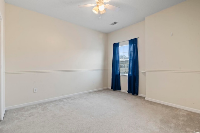 carpeted empty room featuring visible vents, ceiling fan, and baseboards