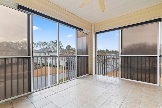 unfurnished sunroom with ceiling fan