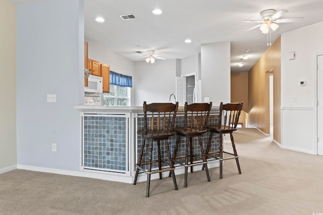 dining room with light carpet, baseboards, a ceiling fan, and recessed lighting