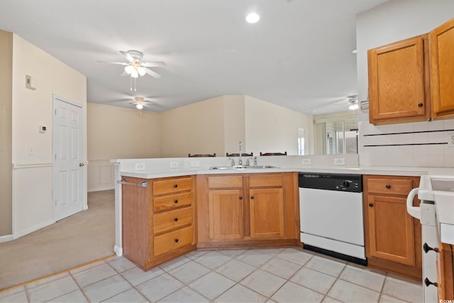 kitchen with a peninsula, ceiling fan, light countertops, and dishwasher