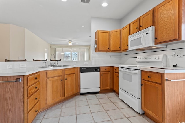 kitchen with white appliances, visible vents, a peninsula, light countertops, and a sink