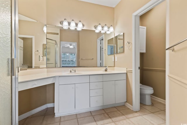 bathroom featuring double vanity, toilet, a ceiling fan, a stall shower, and a sink