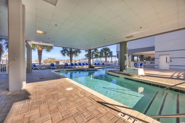 view of pool with a water view and a patio