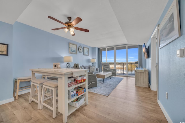 interior space with floor to ceiling windows, light hardwood / wood-style flooring, and ceiling fan