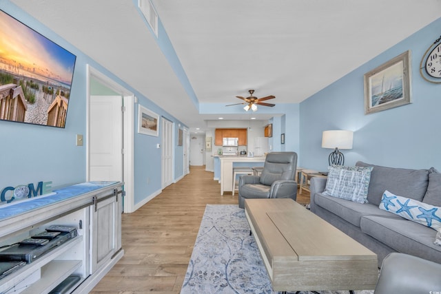 living room with ceiling fan and light hardwood / wood-style flooring