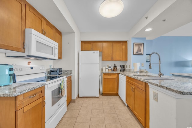 kitchen with kitchen peninsula, sink, white appliances, light stone countertops, and light tile patterned floors